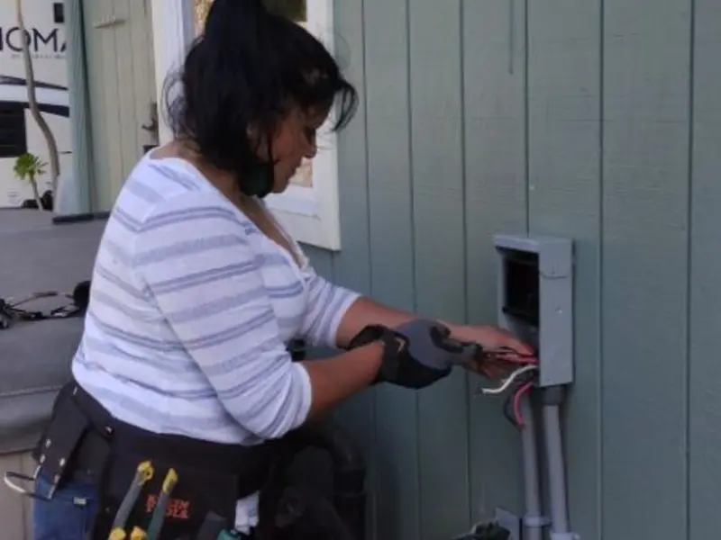 Licensed electrician wiring an exterior subpanel in Troy
